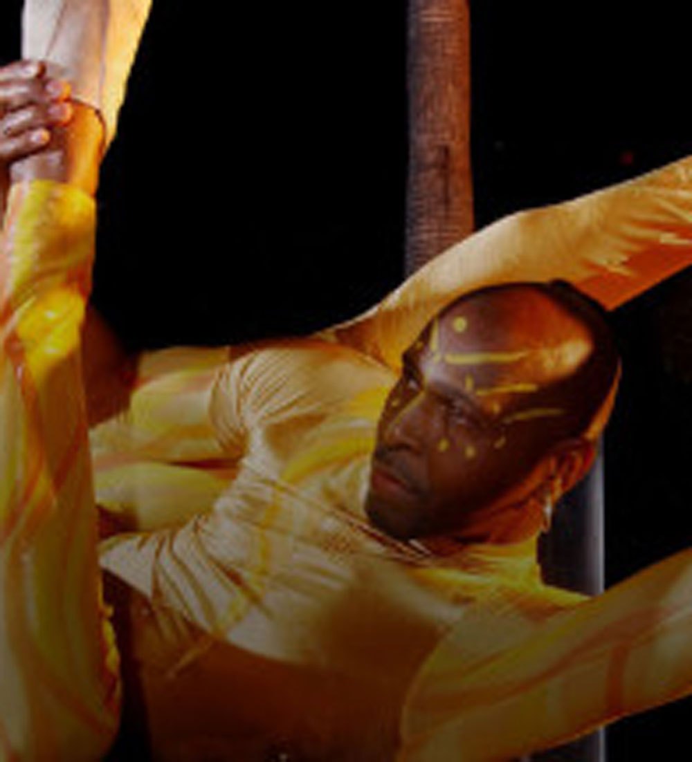 African american cirque style performer wearing a gold leotard.