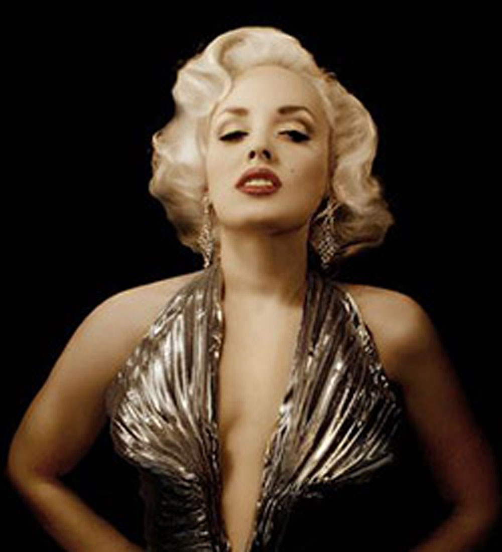 Marilyn Monroe celebrity impersonator caucasian female with short blond hair wearing red lipstick and an elegant silver dress.